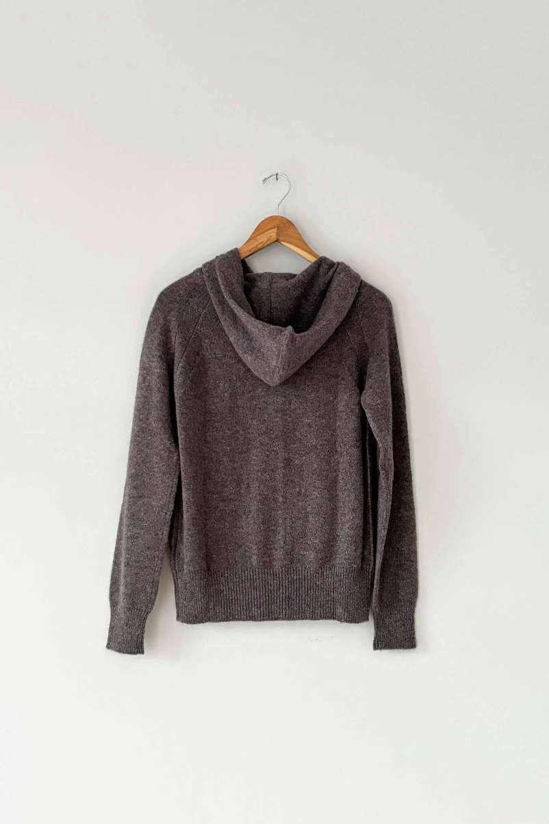 Image of the back of a brown button up hoodie sweater on a wooden coat hanger. 