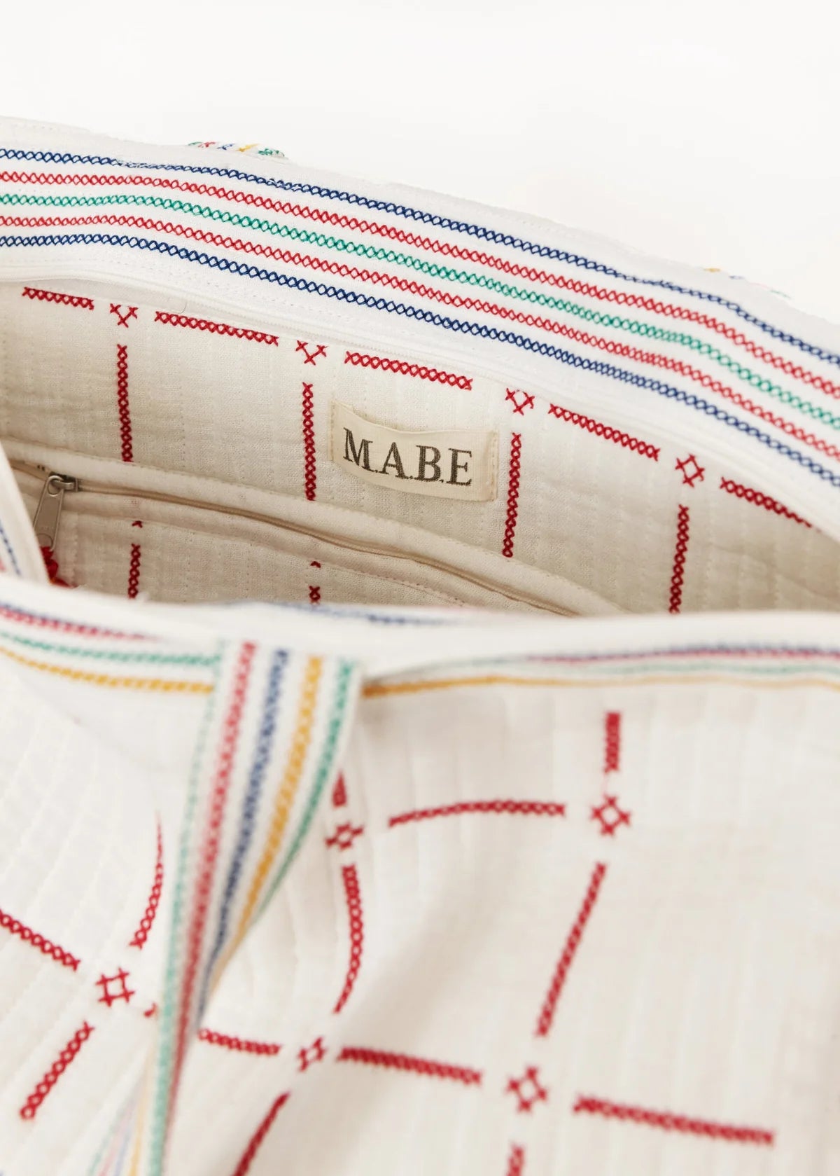 Close-up of a fabric with colorful stitching and 'Mabe' branding.