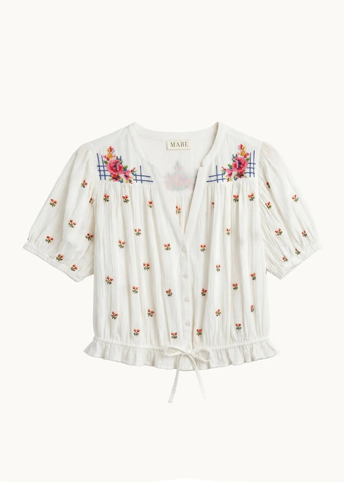White blouse with floral embroidery on a white background