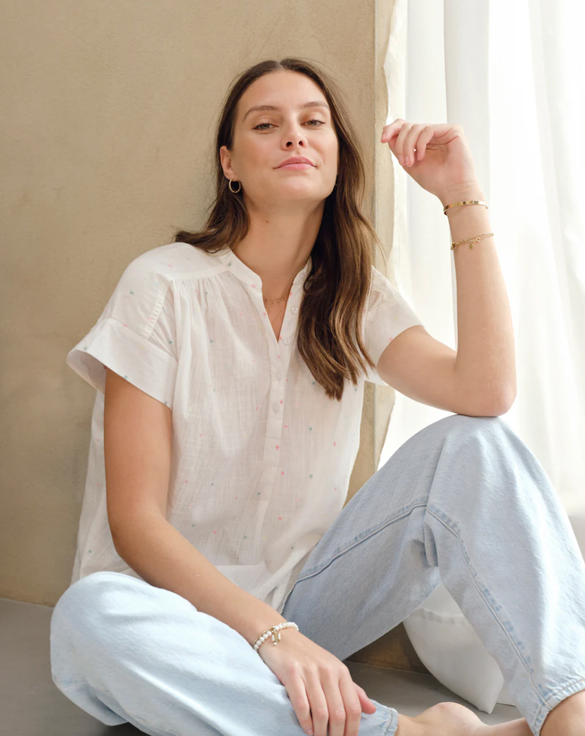 Women sitting wearing white shirt and jeans in MABE