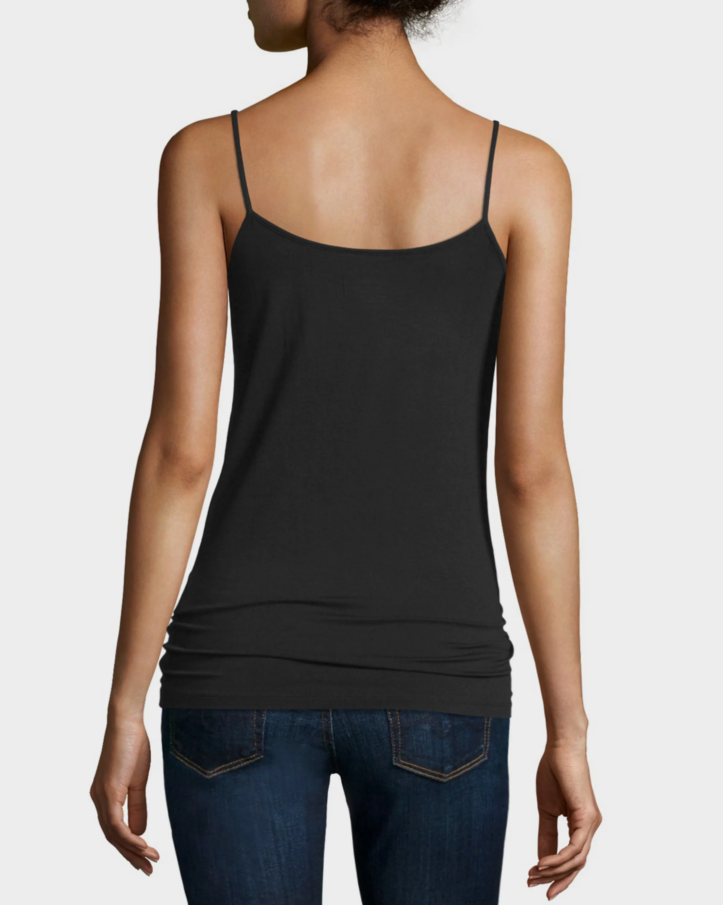 Person wearing a black tank top and blue jeans on a white background