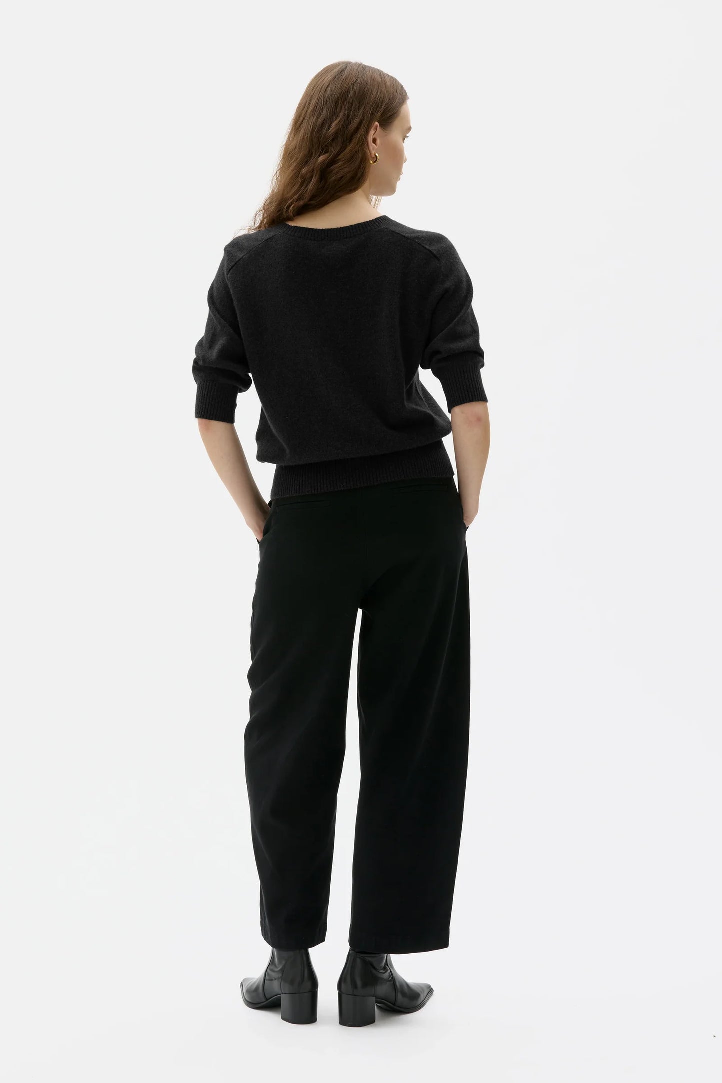 Person wearing a black outfit on a white background
