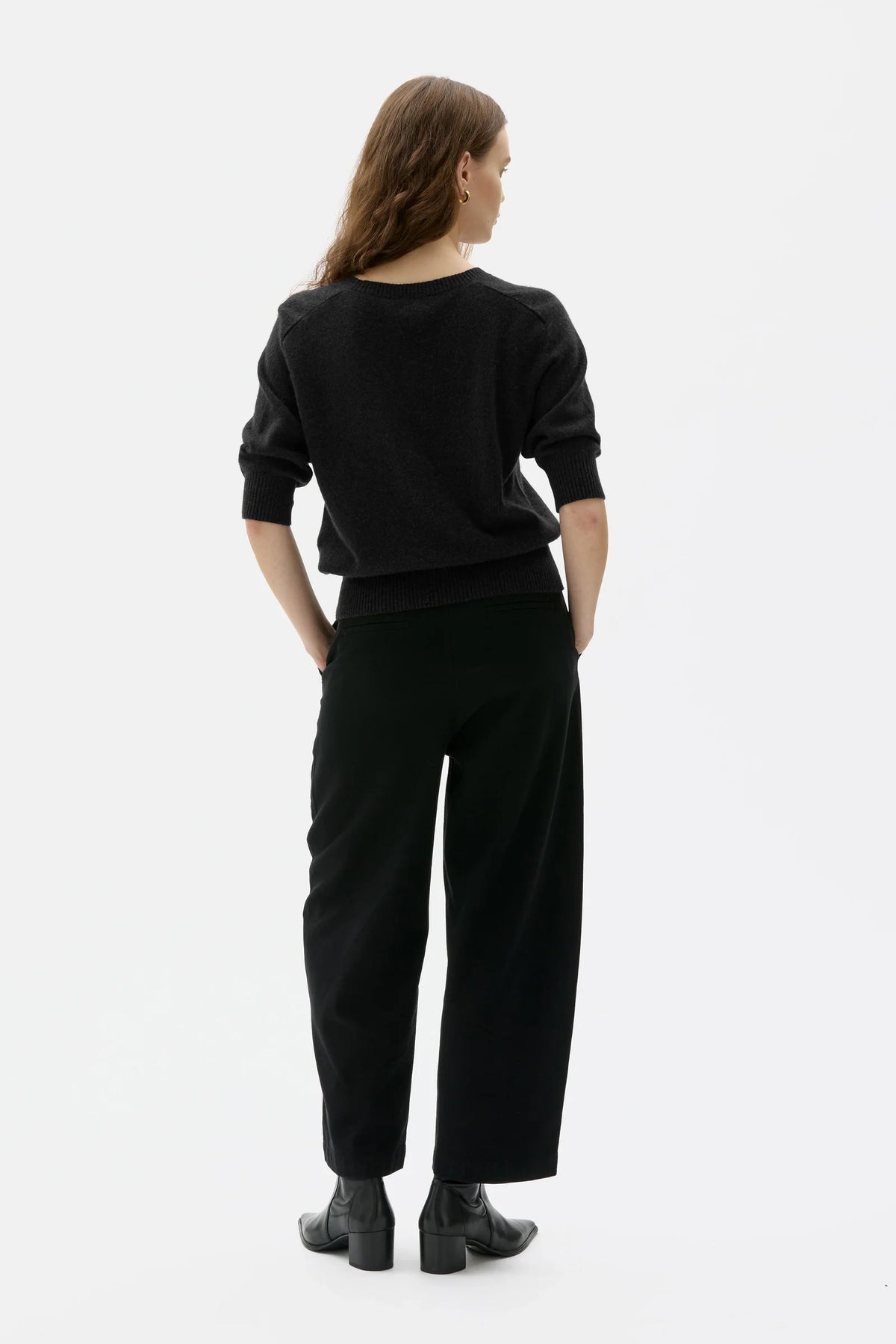 Person wearing a black outfit on a white background