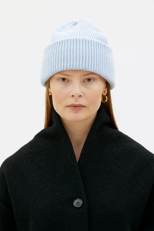 woman wearing sky blue knitted hat and black wool coat