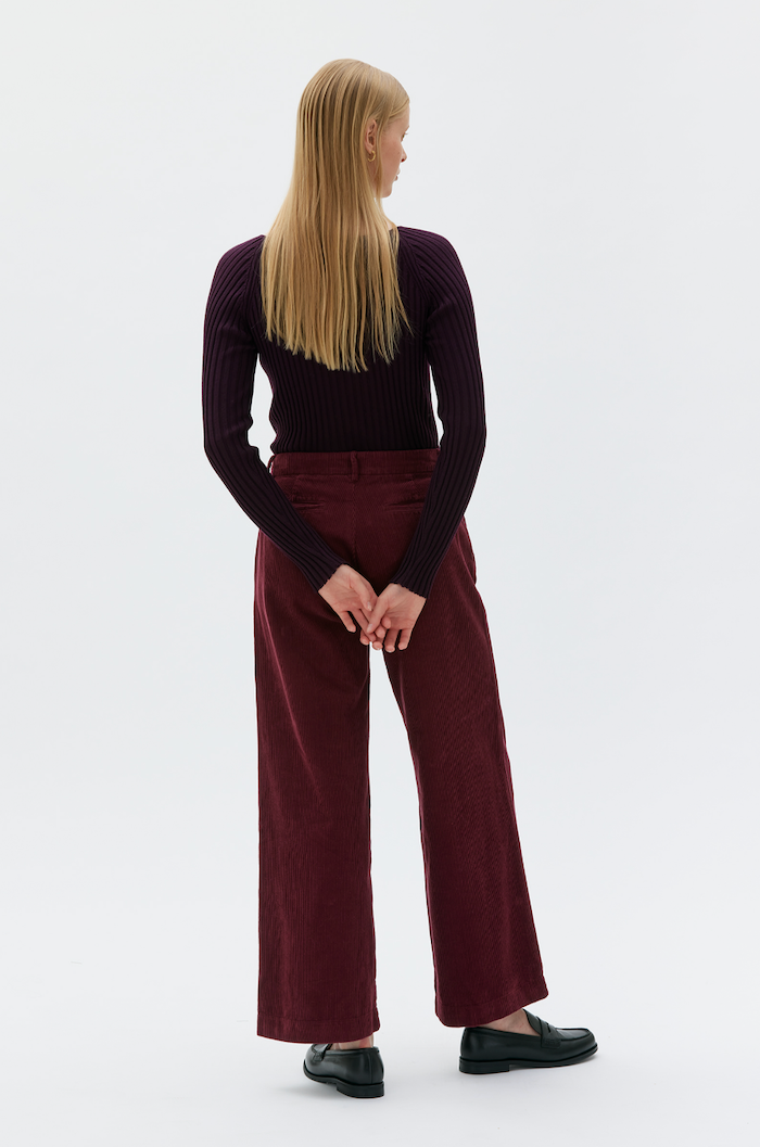 rear view of woman wearing burgundy pants and long sleeve t-shirt