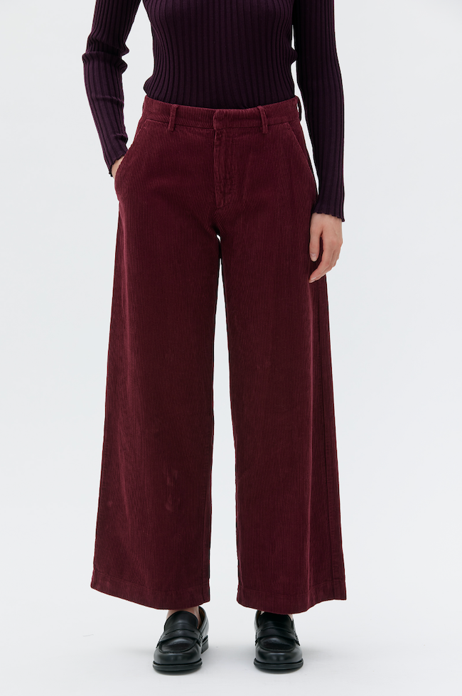 Detail front view of woman wearing burgundy pants and long sleeve t-shirt