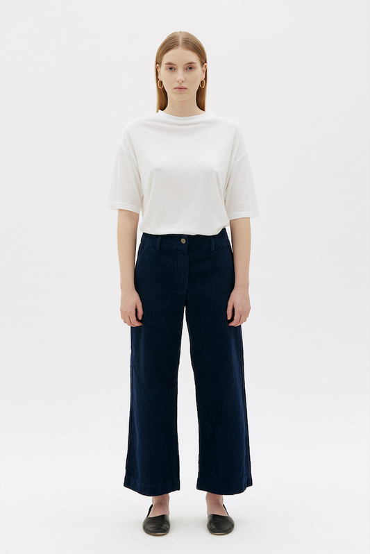 Woman wearing royal blue corduroy pants with white t-shirt