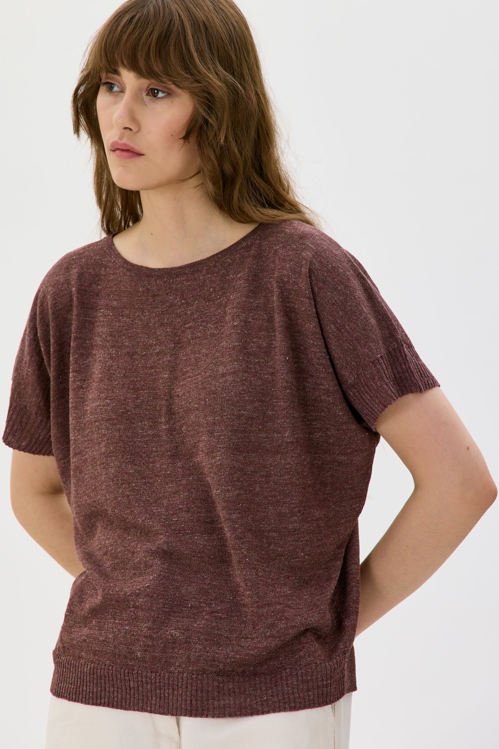 Woman wearing a brown t-shirt against a white background