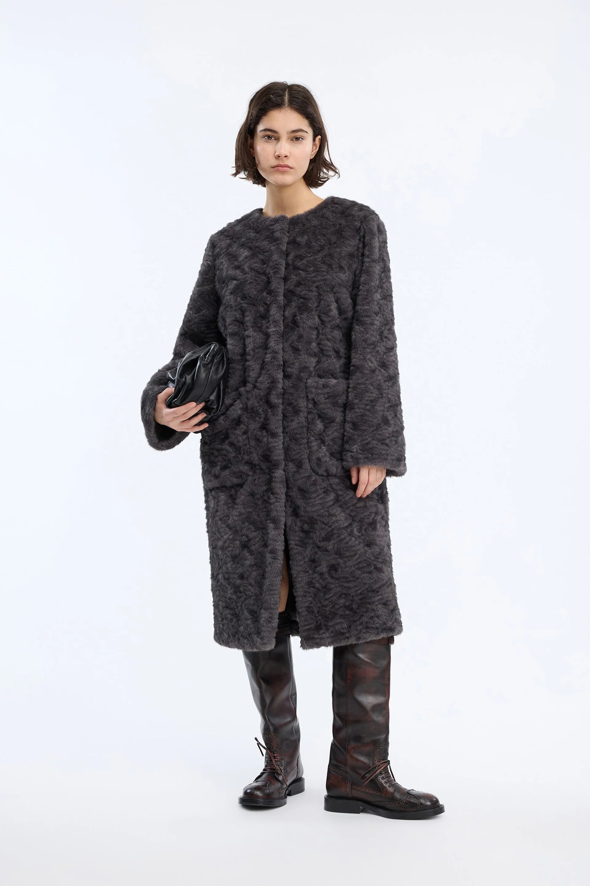 A dark gray textured fleece jacket with a subtle tonal pattern, worn on a posing model.
