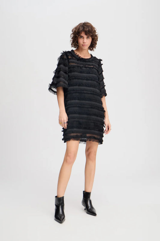 Woman wearing a black dress with ruffled sleeves on a white background