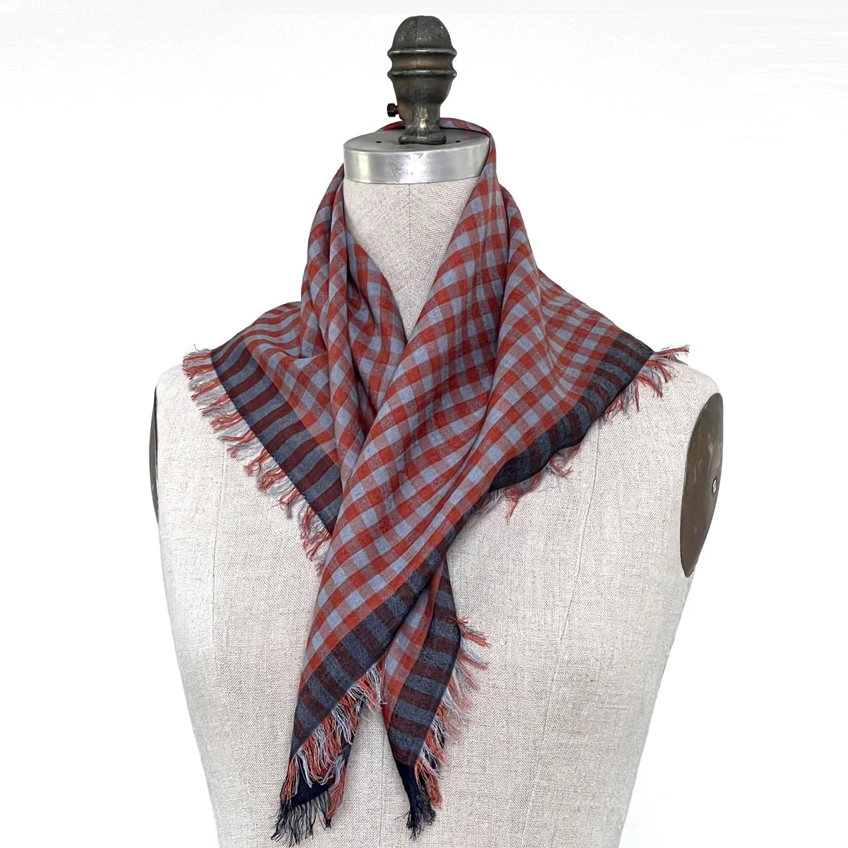 A small blue and orange checkered gingham scarf shown wrapped around a mannequin.