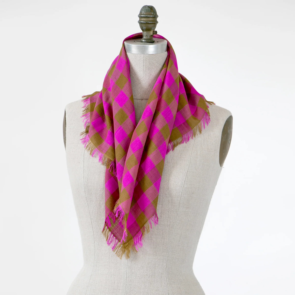 A small pink and green checkered gingham scarf shown wrapped around a mannequin.