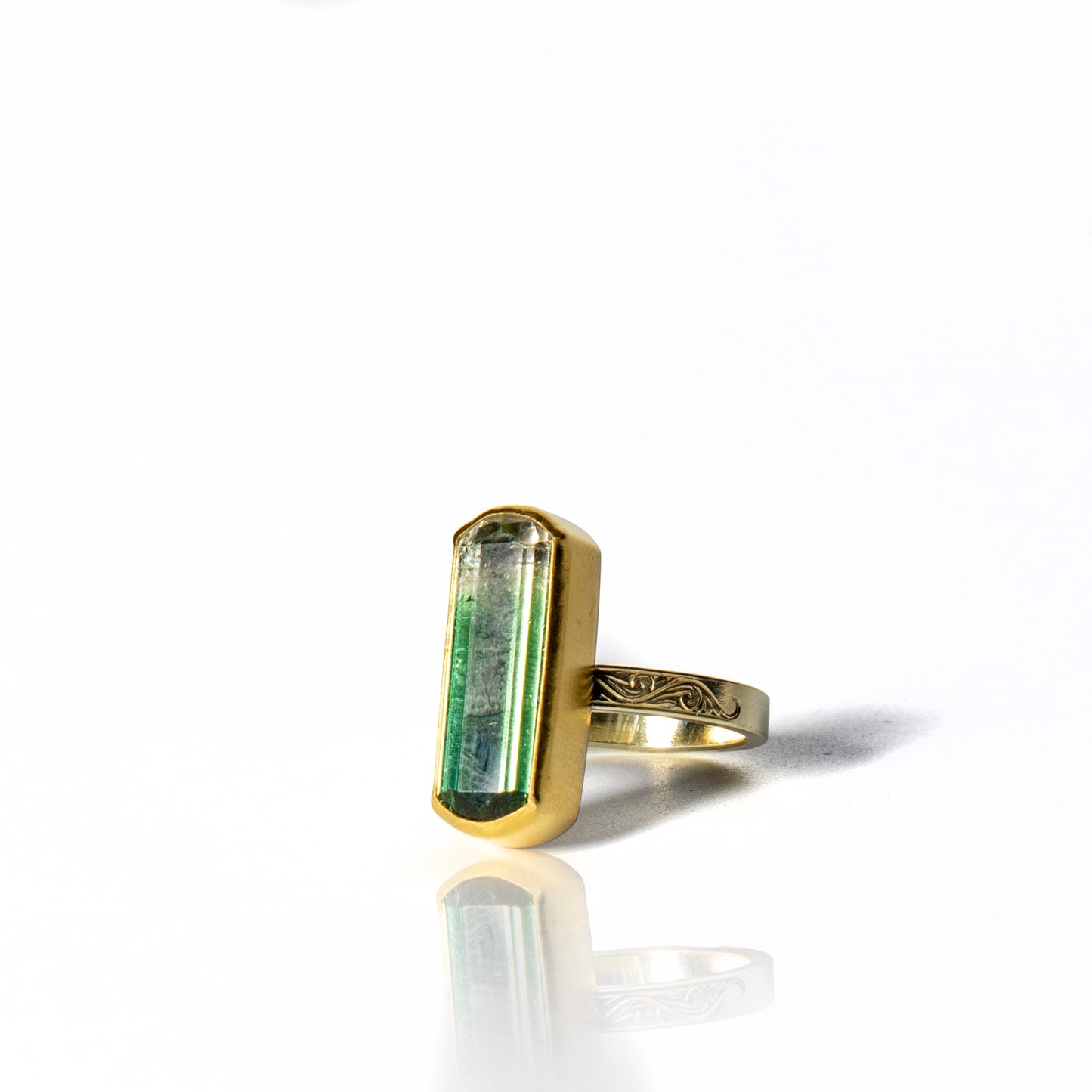 Lozenge shaped green and white fade tourmaline ring with 22k gold setting and silver band