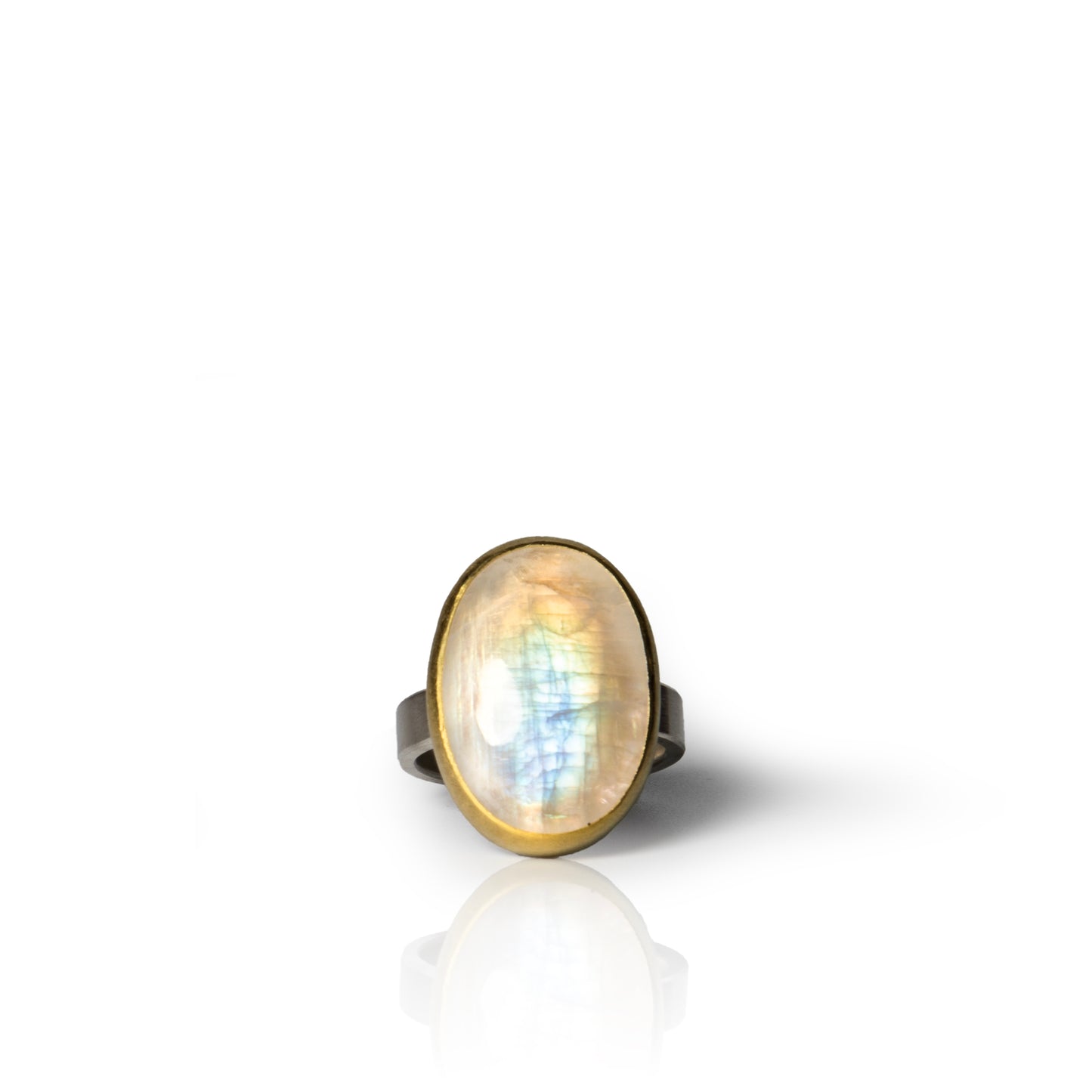 Oval moonstone ring with gold bezel setting and sterling silver band