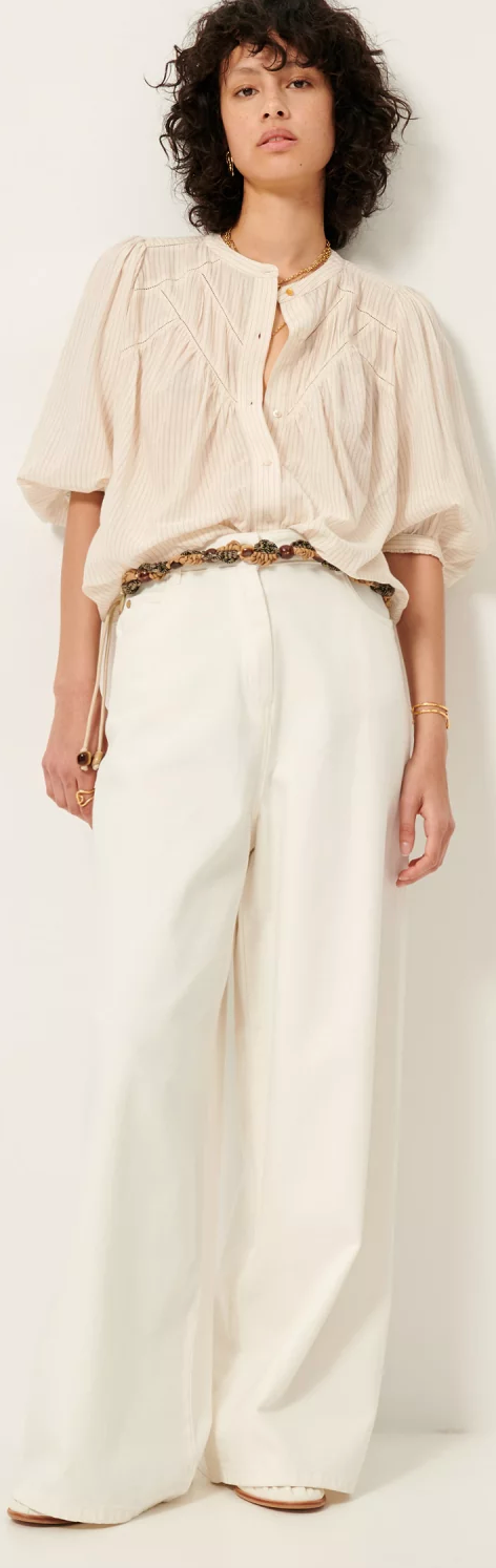 sessun savi blouse worn open with multiple necklaces, tucked into cream wide leg belted pants 