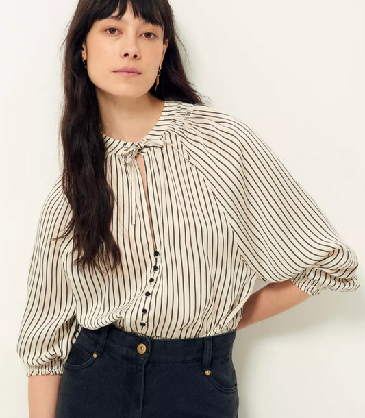 Stripe white and black blouse with tie at the neck and smocking at the waist and cuff. 3/4 sleeve. Worn tucked in to black jeans