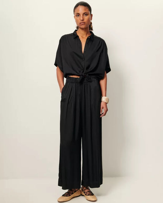 Woman wearing a black jumpsuit on a white background