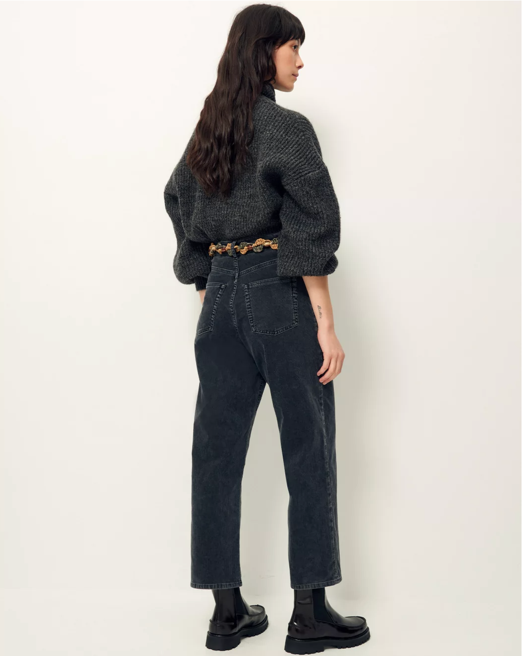 Rear image of woman wearing soft black corduroy cropped pants.