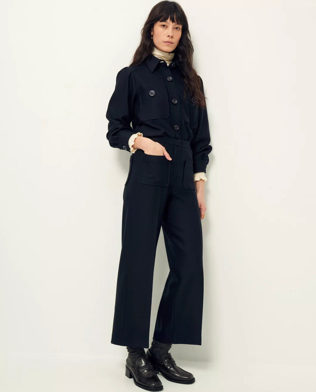 Front view of woman wearing wide leg black wool pants.