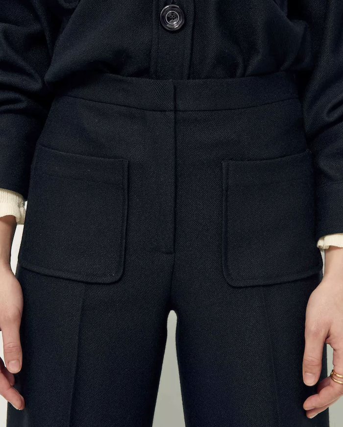 Detail of black wool pants with front patch pockets.