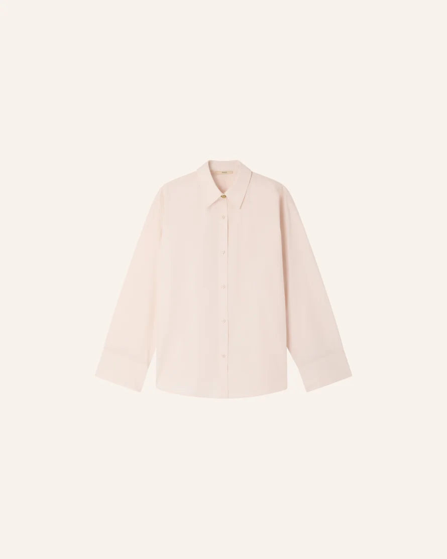 A pale blush pink long-sleeve button-up shirt with a pointed collar, displayed flat against a solid off-white background.