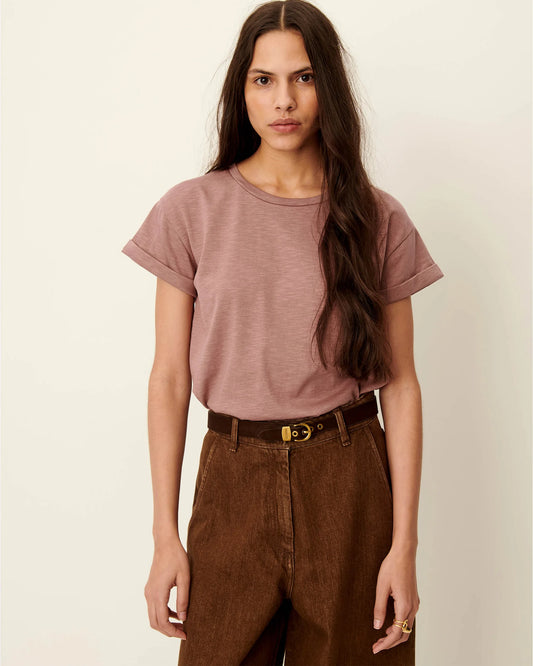 Model wearing a marble rose short sleeve T-shirt  with a cuff on the sleeve. White background