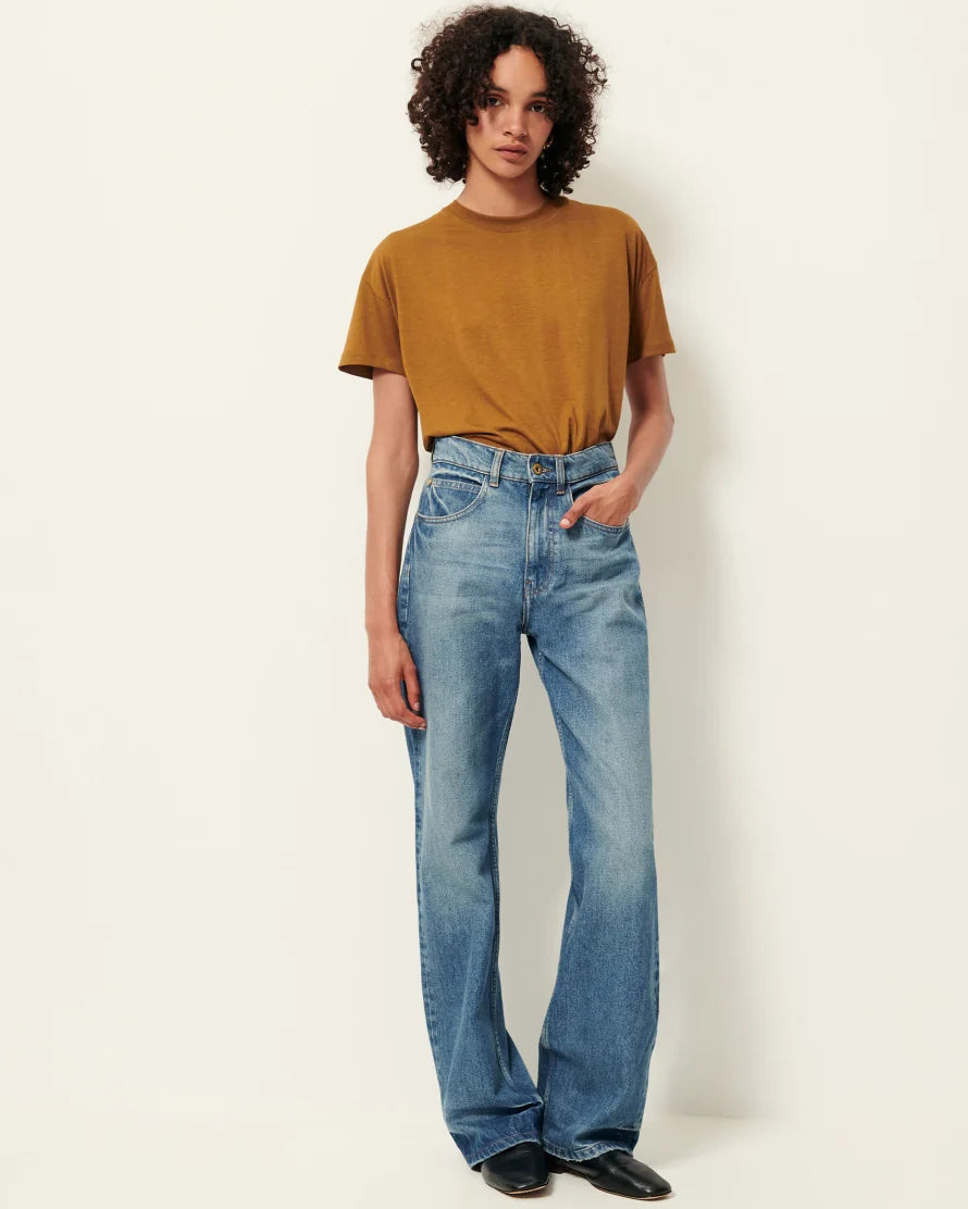 Model wearing a bronze short sleeve T-Shirt with jeans. White background