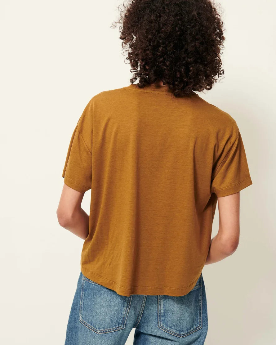 Back view of a Model wearing a bronze short sleeve T-Shirt with jeans. White background