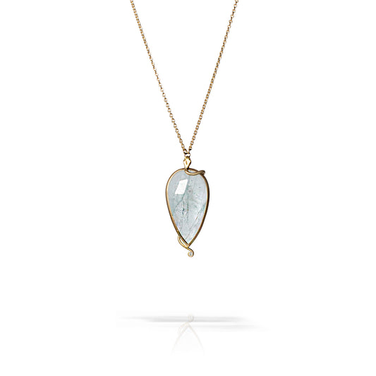 A teardrop-shaped pendant necklace featuring a clear, fibrous gemstone in a gold-toned bezel setting on a delicate chain, shown against a white background with a soft reflection below.