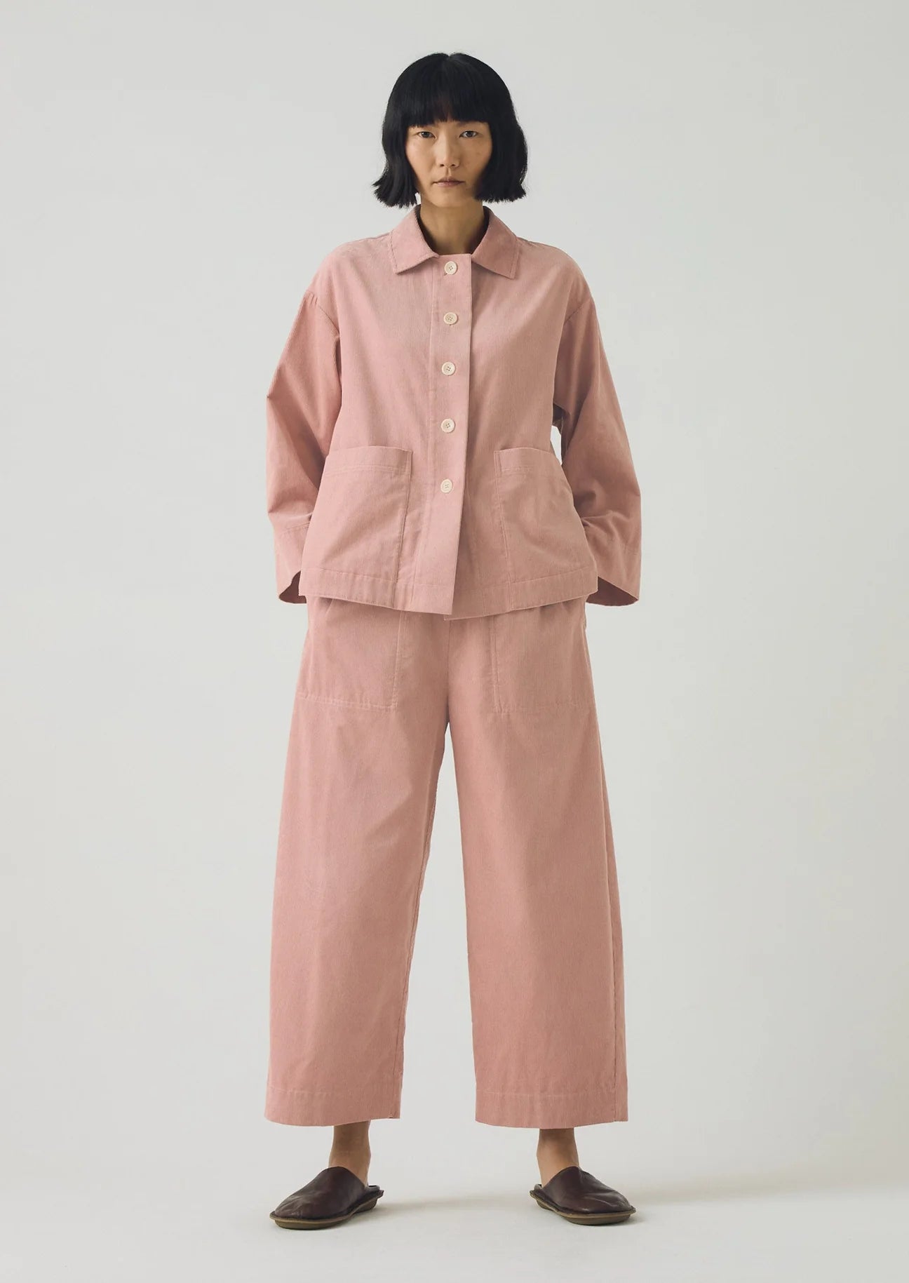Person wearing a pink outfit on a white background