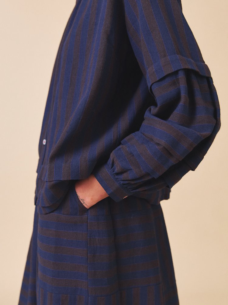 Navy blue and gray striped shirt on a beige background