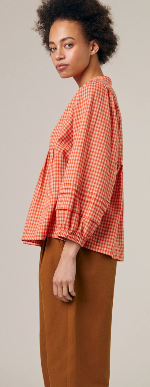 side view of check shirt with full sleeve and gathered front and back yoke seams. Worn with pleated pants