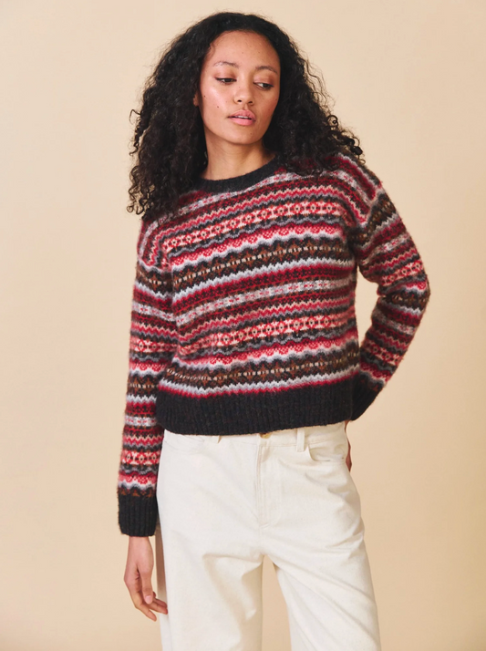 Woman wearing a patterned sweater against a beige background