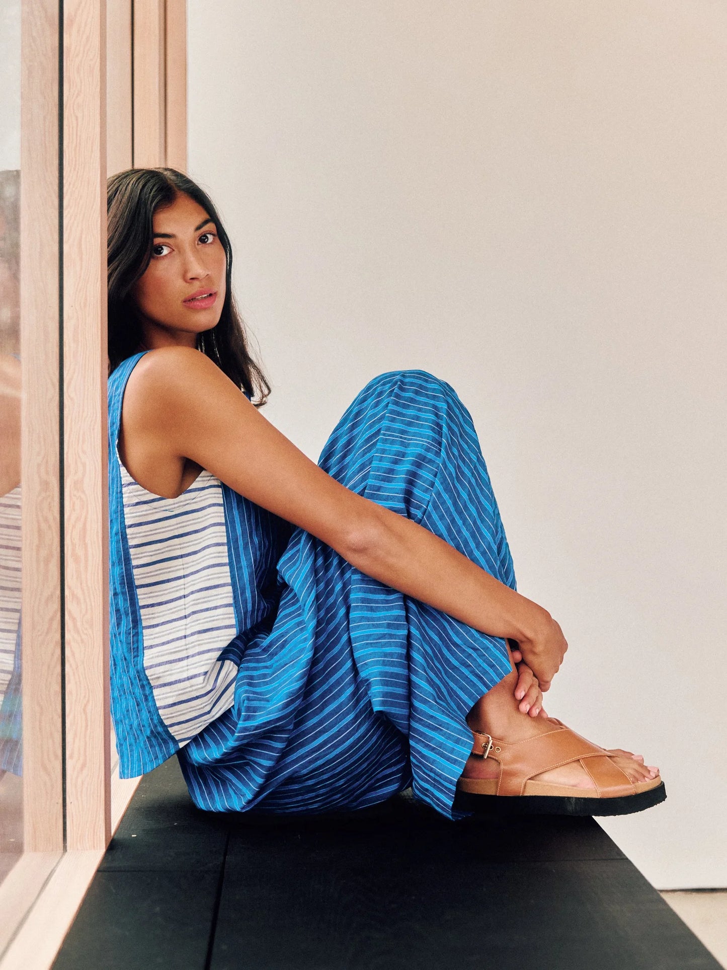 Model is seated showing side view of stripe top and pant. Contrast side stripe panel is shown in this view