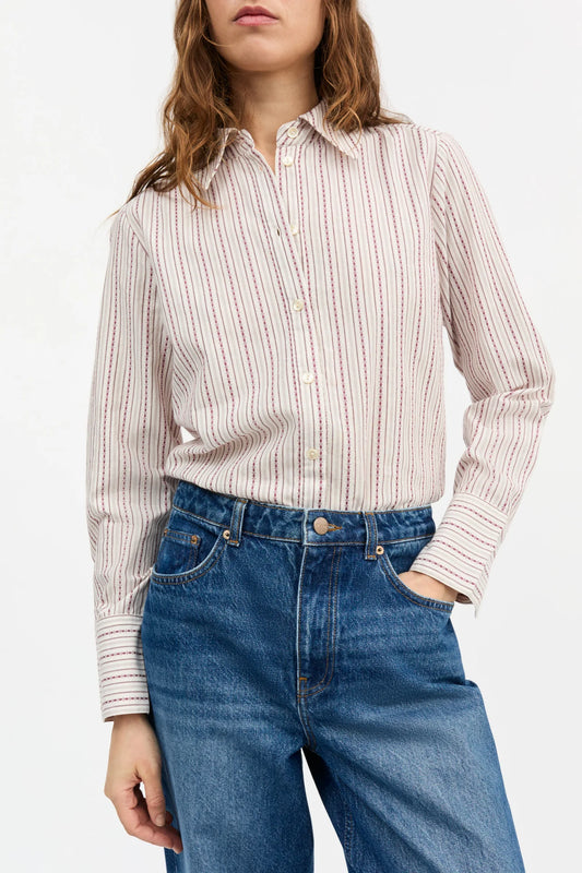 Person wearing a striped shirt and blue jeans on a white background
