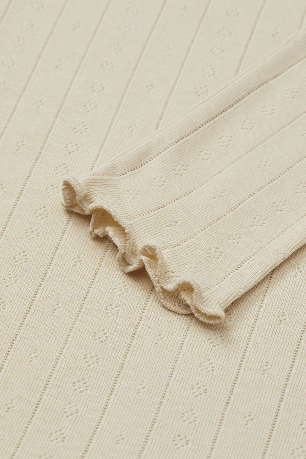 Close-up of a textured fabric with a ruffled edge on a matching background