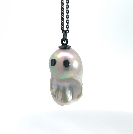 White baroque pearl necklace shaped like a ghost with dark silver eyes on oxidized silver chain