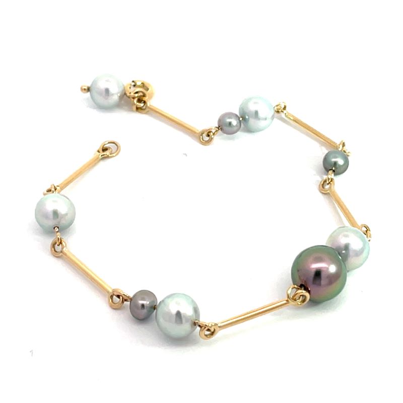 A gold chain bracelet featuring freshwater pearls in white, light blue-green, and a large dark green-gray pearl, displayed on a clean white background.
