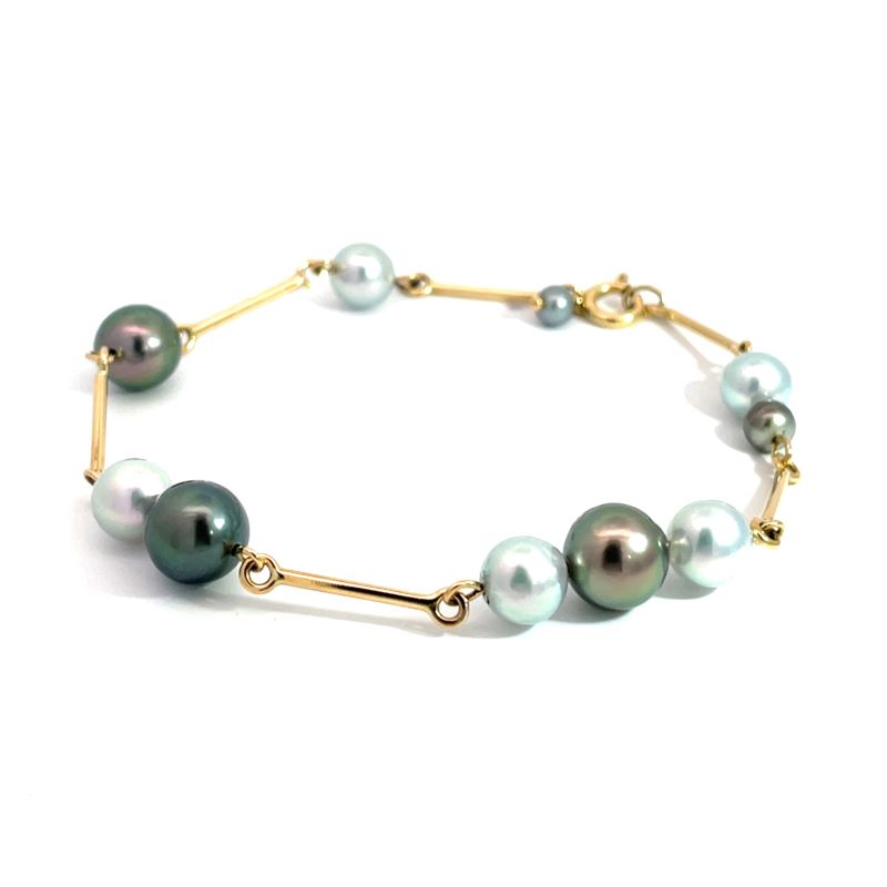 A gold bracelet featuring a series of round freshwater pearls in white, pale blue, and dark green-gray tones, displayed on a clean white background.