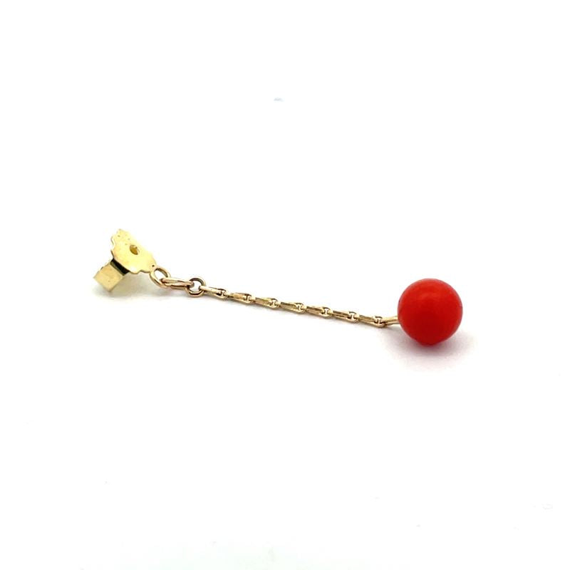 A single drop earring featuring a small gold chain leading to a smooth, spherical red coral bead, shown on a plain white background.