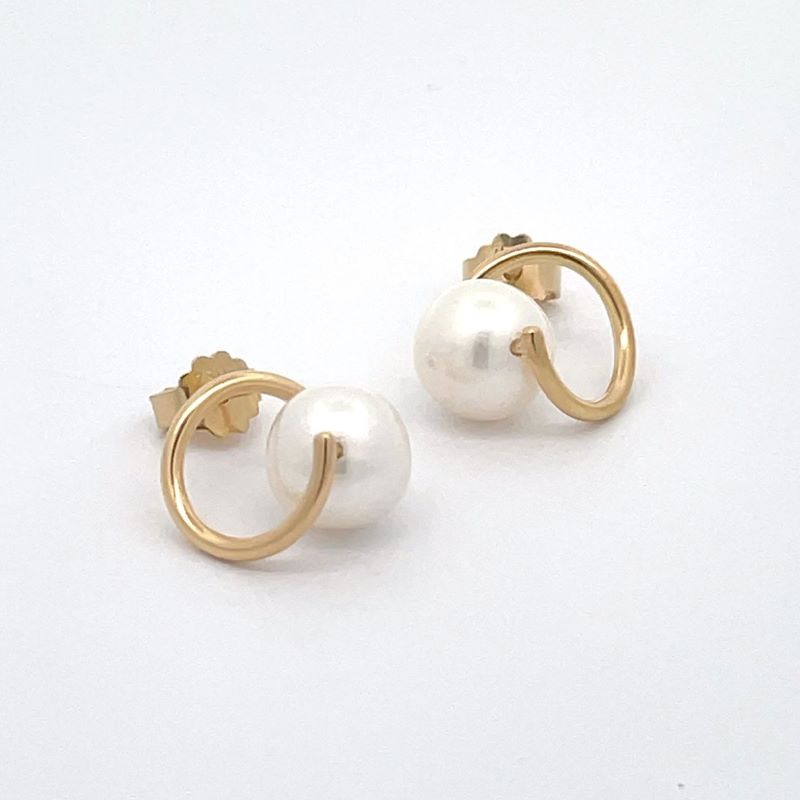 A pair of gold earrings with a single white pearl suspended in the center of each twist, shown on a plain white background.