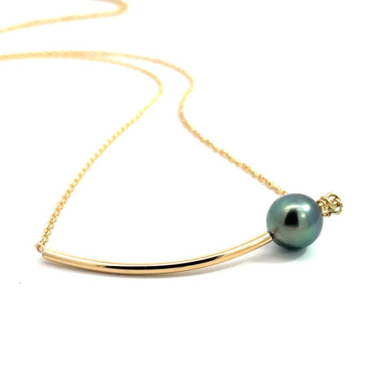 A curved yellow gold necklace with a dark green pearl.