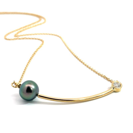 A gold necklace featuring a curved bar pendant with a dark green iridescent pearl and a small round diamond, shown on a white background.