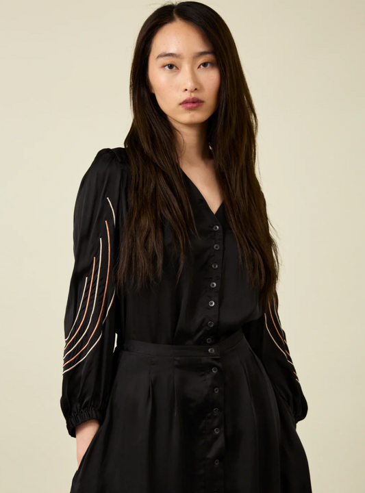 woman with long dark hair wearing black Bemberg shirt with black embroidery