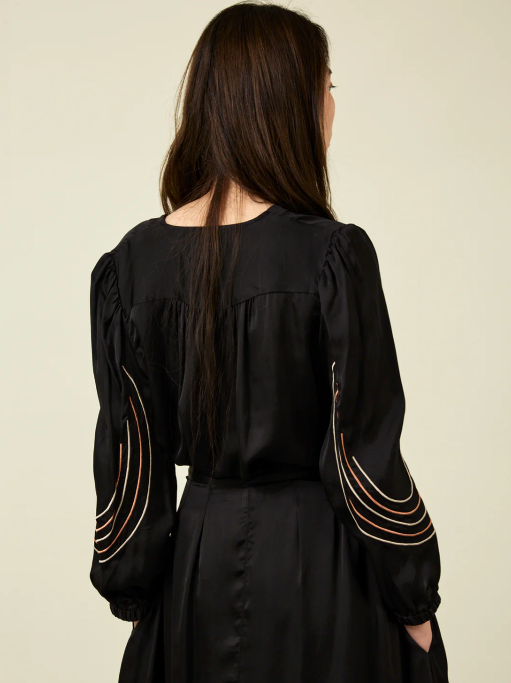 rear view of woman with long dark hair wearing black Bemberg shirt with black embroidery