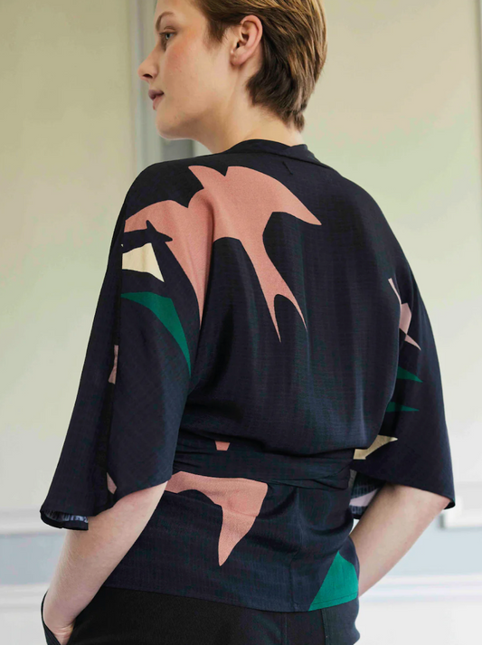 Woman wearing kimono style wrap shirt rear view