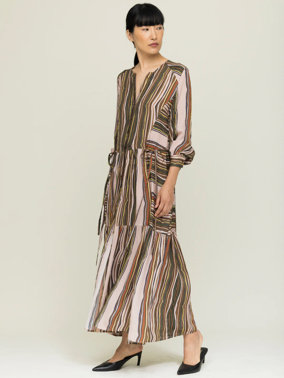 Woman wearing a striped dress on a plain background