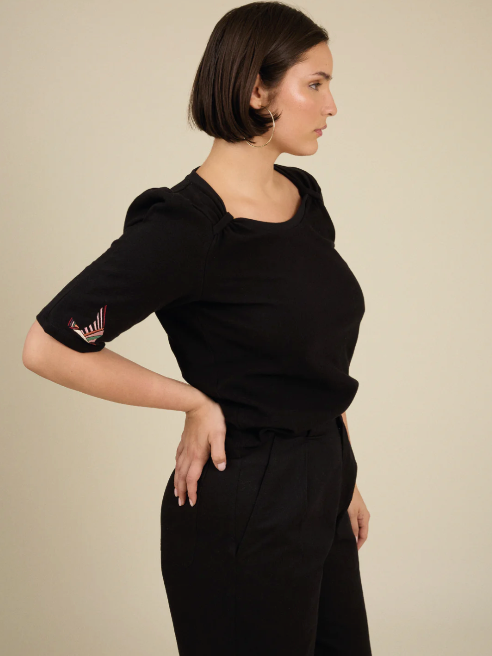 Woman wearing scoop neck embroidered black t-shirt 