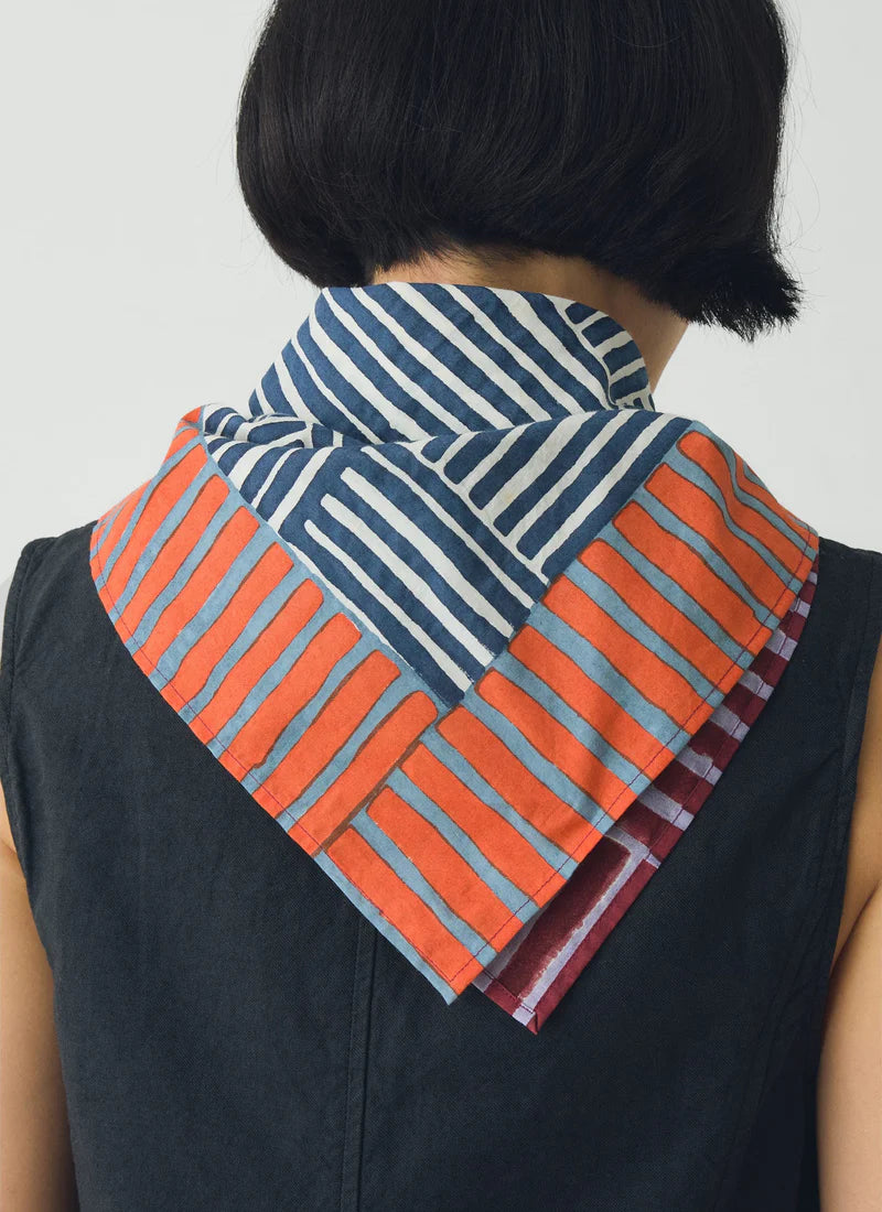 Back view of a person wearing a block print bandana around her neck. White background