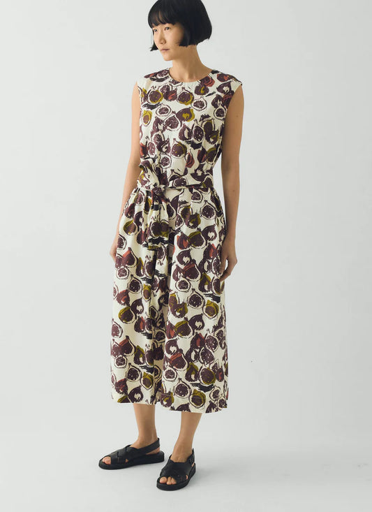Woman wearing a sleeveless dress with a floral pattern on a white background